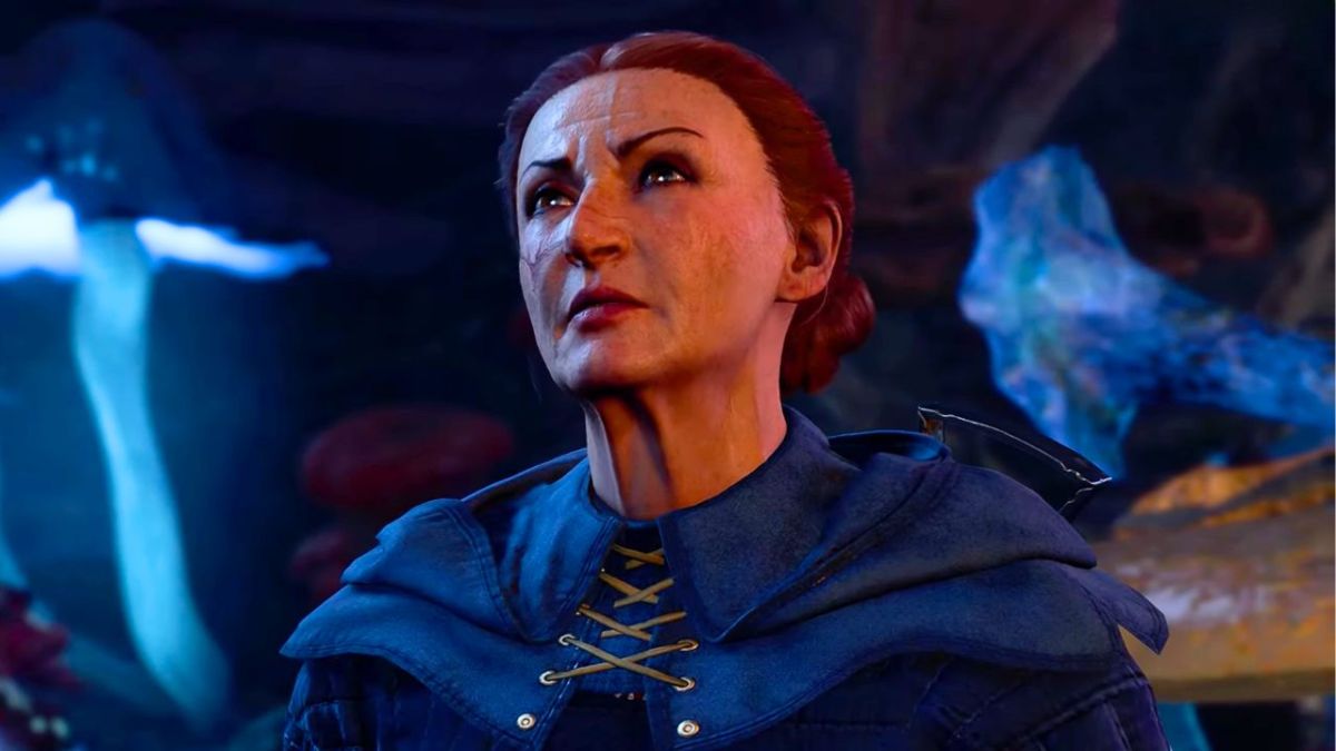 Older woman wearing a blue cloak with her hair tied up and a stern face in BG3