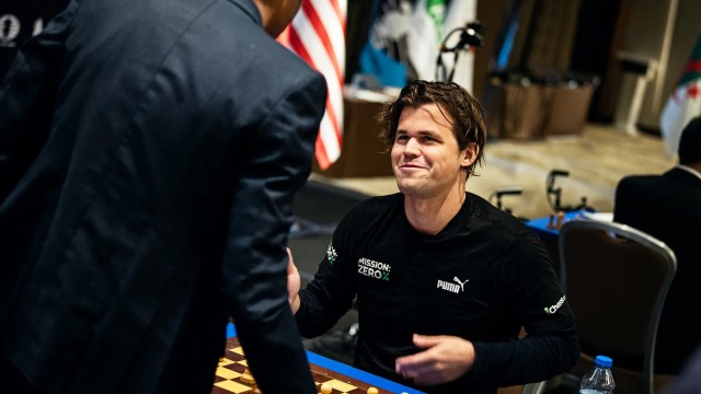 A picture of Magnus Carlsensitting on a chair, wearing black.
