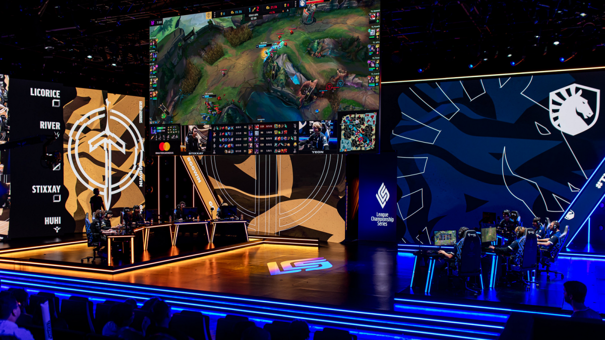 an LCS stage with two league teams playing against each other, sat at desks with computers on them