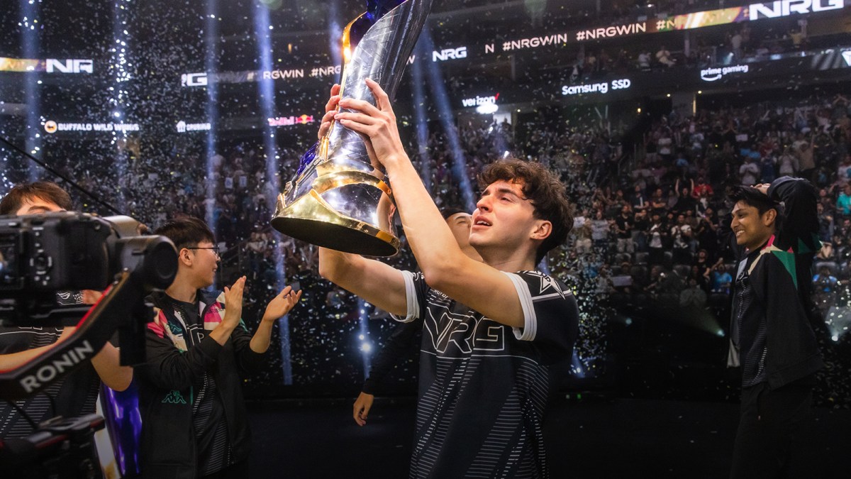 Contractz holds up the LCS Championship trophy in front of a crowd of League of Legends fans as his teammate Dhokla watches on