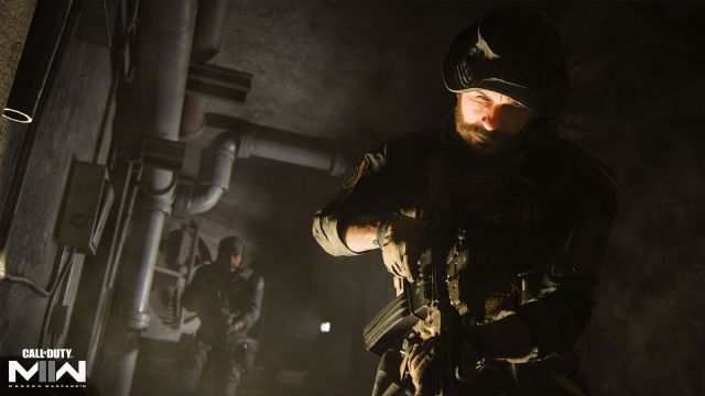 Image with Captain Price from the Call of Duty Franchise visible on the screen at the forefront. There is a small tunnel with pipework lining the outskirts of the area.