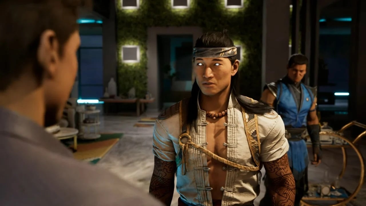 Fire God Liu Kang is standing in front of Sub-Zero, with Johnny Cage in the foreground. They are in suite.