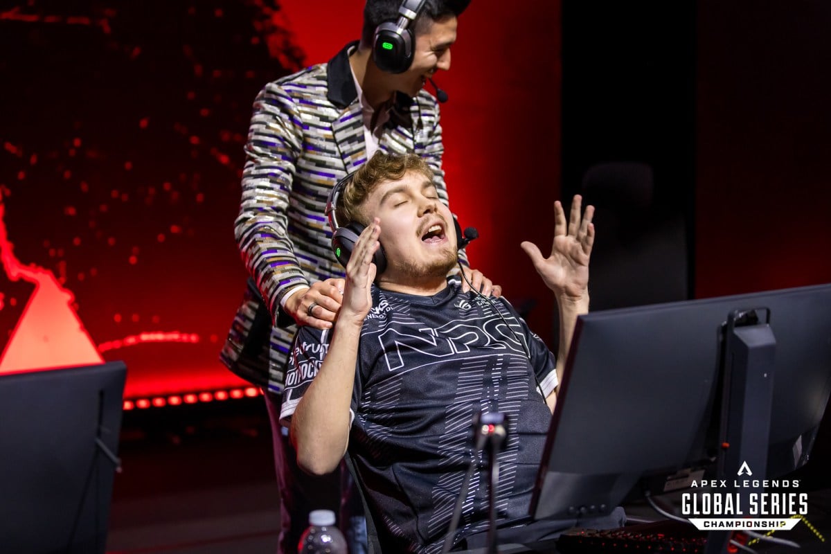 NRG Sweet leans back in his chair with his arms up as his coach places his hands on his shoulders from behind.