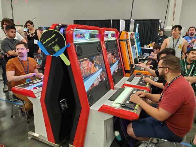 Players sit at arcade cabinets playing FGC titles at Evo Japan.