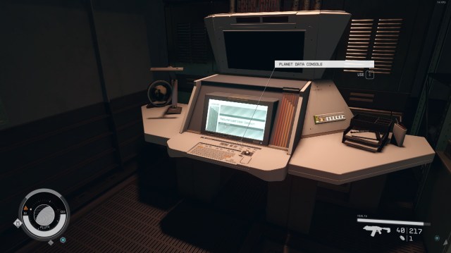 A computer terminal turns on, lit by a nearby lamp in a room in Starfield.