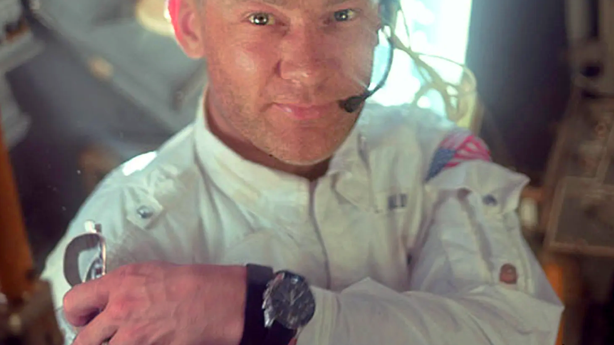 Buzz Aldrin, astronaut, in full space gear showcasing his Omega Speedmaster watch.