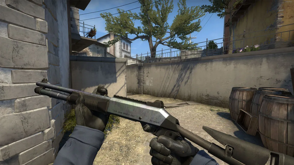 A player inspects their shotgun standing in a pathway on Inferno in CS:GO.