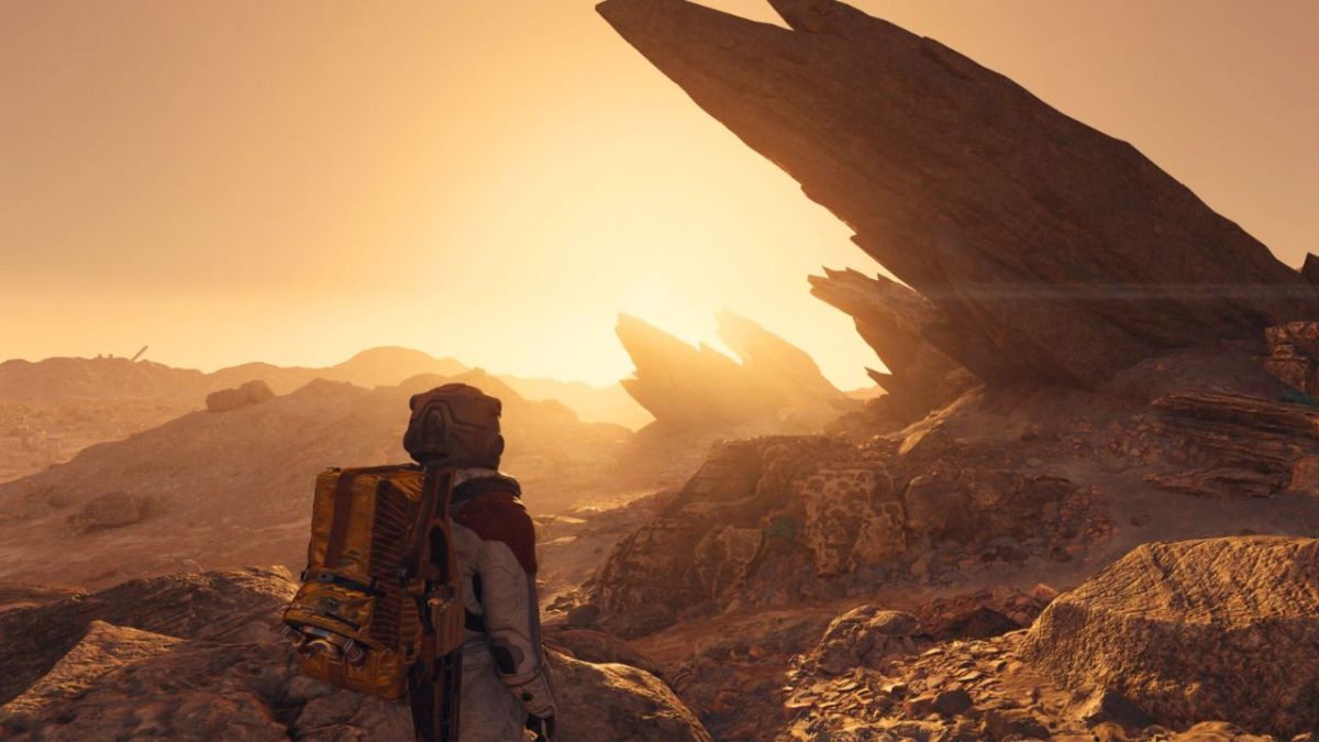 An astronaut standing in the sunlight near a large rock in Starfield