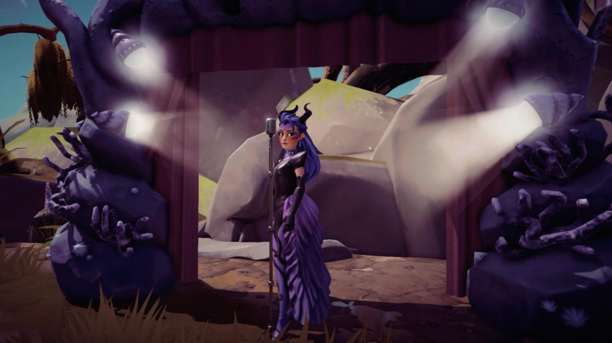 The player dressed in Ursula themed attire standing by a microphone in front of a sea stage.