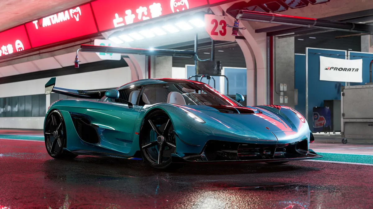 A blue car sinks low into a wet circuit beneath neon lights.