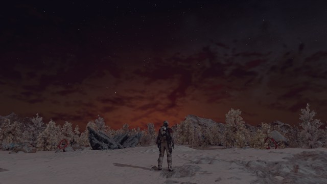 An astronaut stands on the snow near a forest, watching the sunset.