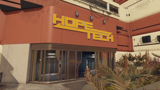 A factory entrance to HopeTech, in orange, outside a garden bed on Hopetown in Starfield.