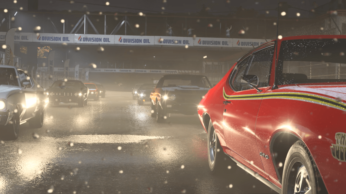Cars on the track at the start of a race in Forza Motorsport, with headlights glaring and specs of rain on the camera.