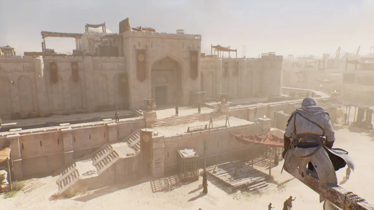Basim perches on a beam, looking at a white stone prison while dust blows through.