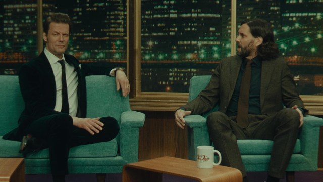 Alan Wake and Alex casey sit on the sofa during a talk show