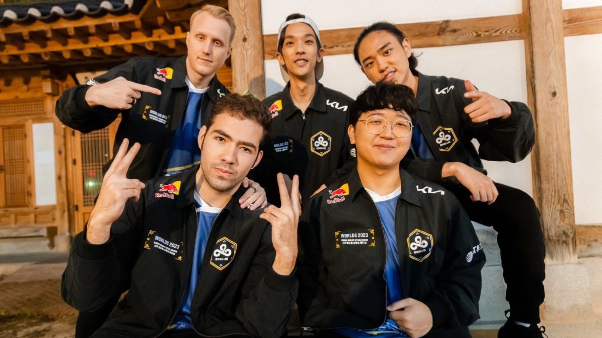 Cloud9 team posing in front of a wooden building ahead of Worlds 2023.