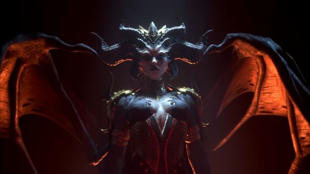 Image showcasing Lilith from Diablo 4 standing with curved bat-like wings lit in an orange glow and horns on her head. Lilith is also featured as a statue in the Ghost Train in The Haunting event.