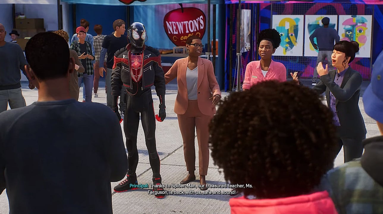 There is a shot of Miles Morales with the head of the Brooklyn Visions Academy. There are people all around them cheering and smiling. 