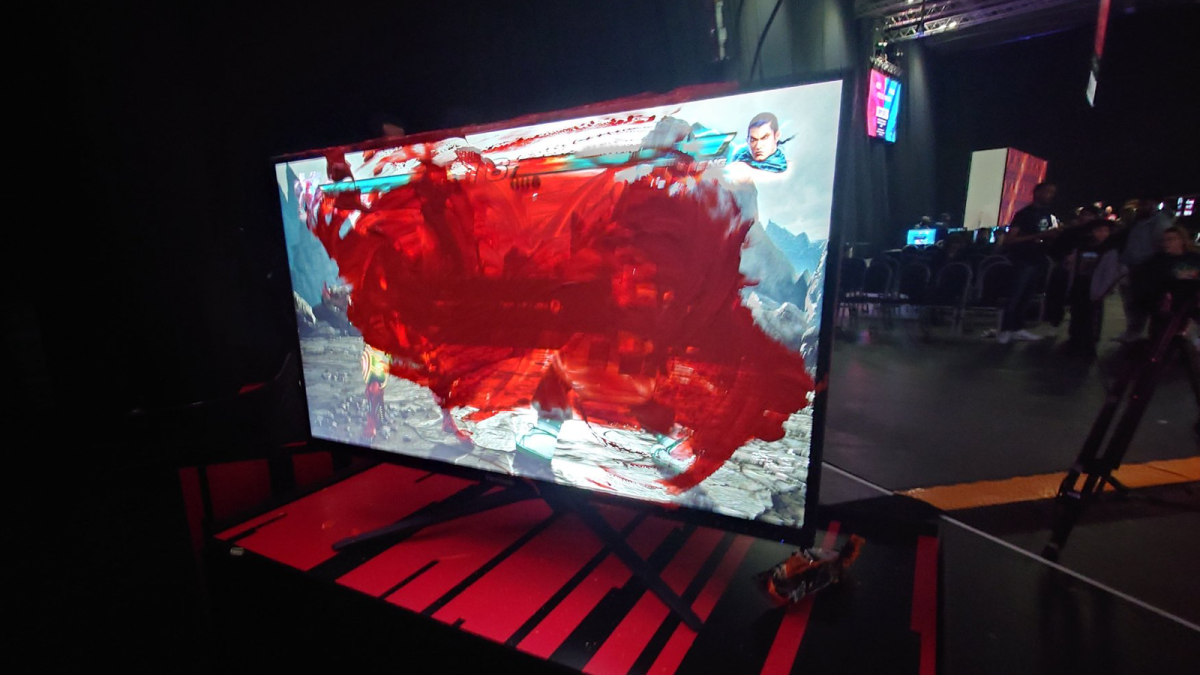 A monitor playing Tekken 7 covered in orange paint.