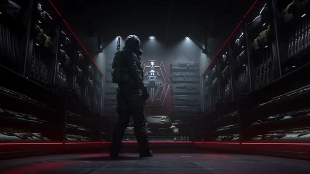 Image from the MW3 multiplayer trailer which shows a character in a dimly lit weapon room. There is a red banner in the wall in the background.