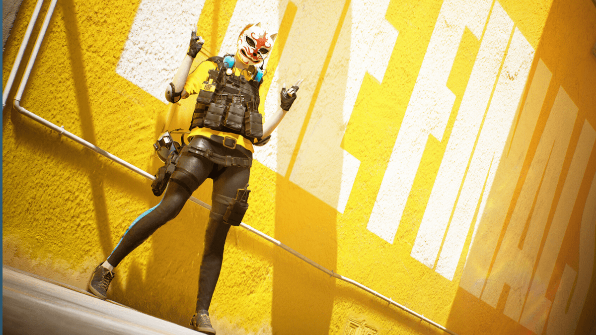 A women with gear standing against a yellow wall.