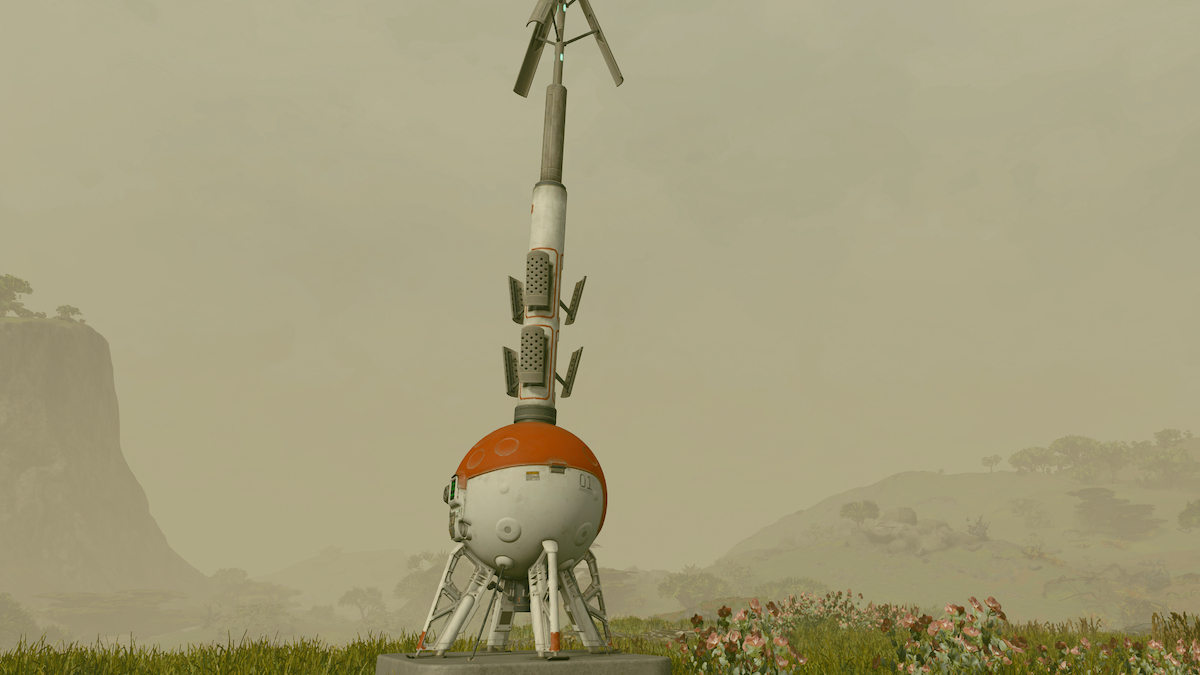 An outpost beacon, a spherical red and white orb with an antenna sticking out of it, sits in front of a foggy and hilly landscape.