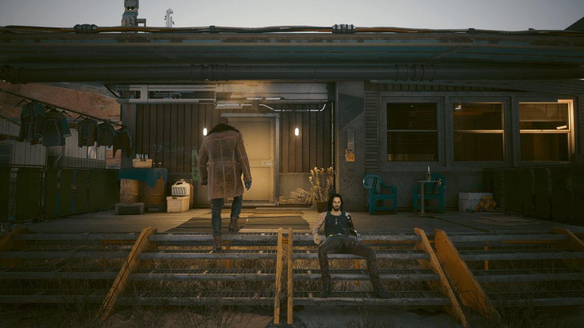 River approaching Randy's trailer while Johnny sits on the stairs during The Hunt (Cyberpunk 2077)