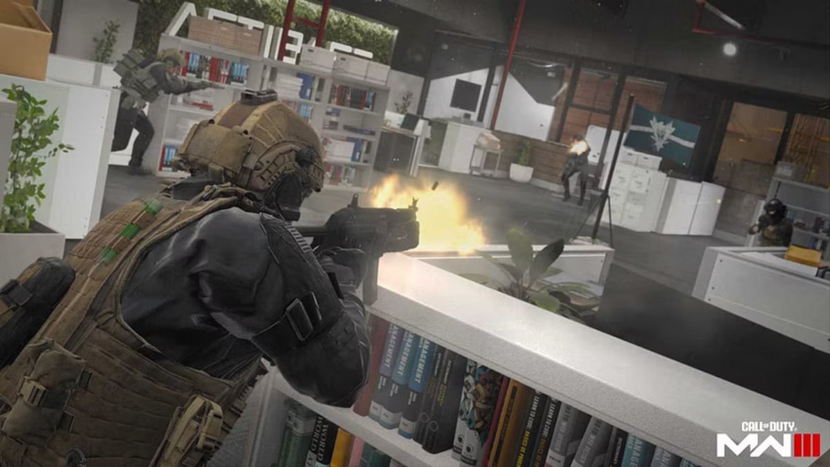 A solider shoots at an opponent while a flag is defended in an office building on Highrise in Call of Duty Modern Warfare  3.