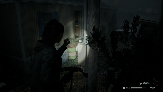 Saga shining her flashlight on the trailer park stash keys, which are on top of a fuse-box (Alan Wake 2).