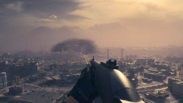 Image from MW3 zombies with a shotgun on screen and a green laser pointer emitting from it. The player is standing on top of a tall building overlooking the map.
