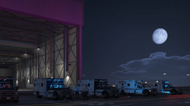 A row of ambulances at the airstrip in GTA 5 with the full moon shining brightly above it.