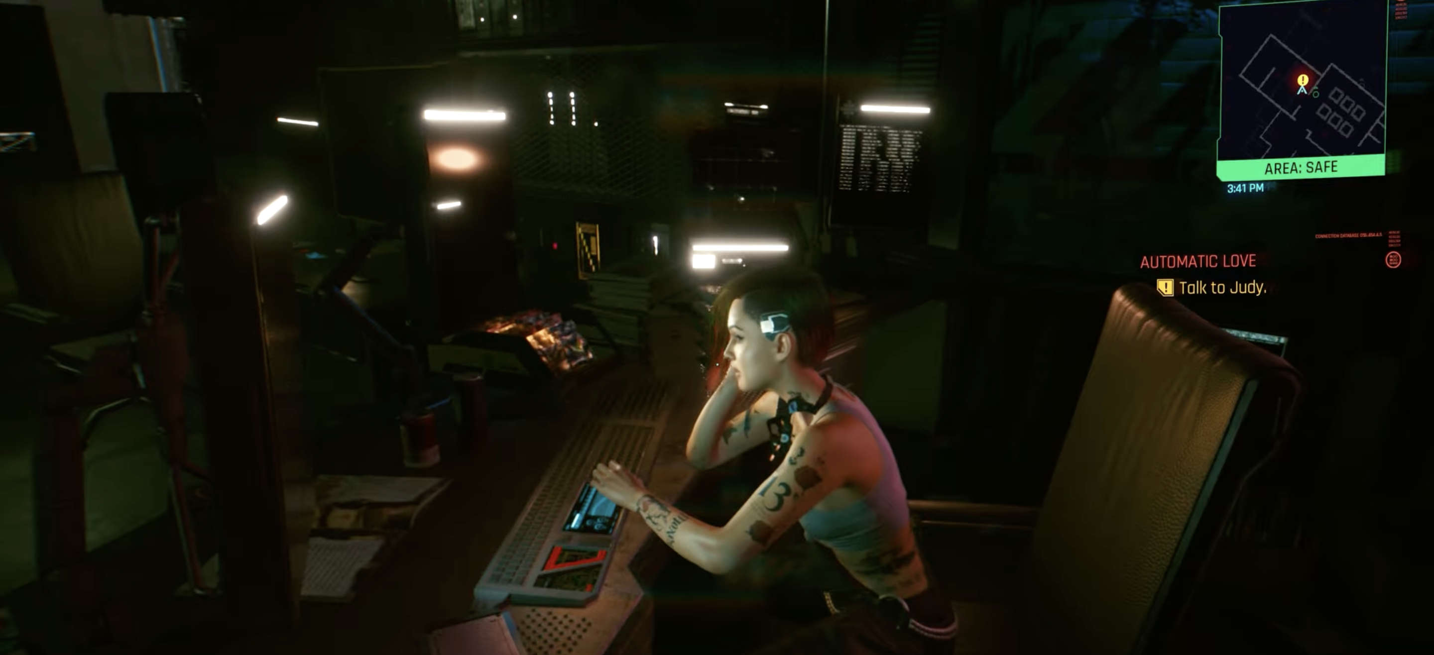 V talks to Judy, who sits at a table, in Cyberpunk 2077.