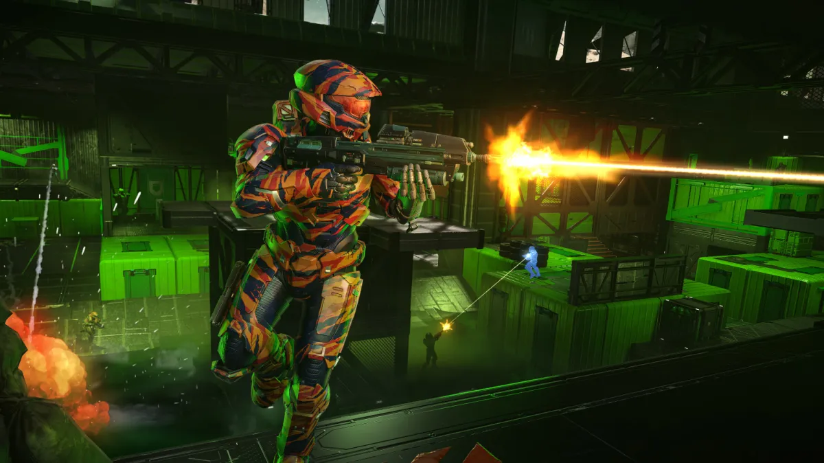 A Spartan fires their assault rifle to the left side of the screen on the Critical Dewpoint map. They are wearing a tiger camo coating consisting of reds, oranges and blacks.