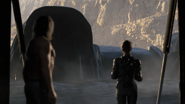 Screenshot of Death Stranding 2's teaser trailer from The Game Awards 2022 showing two characters looking at a massive submarine emerging from black water.