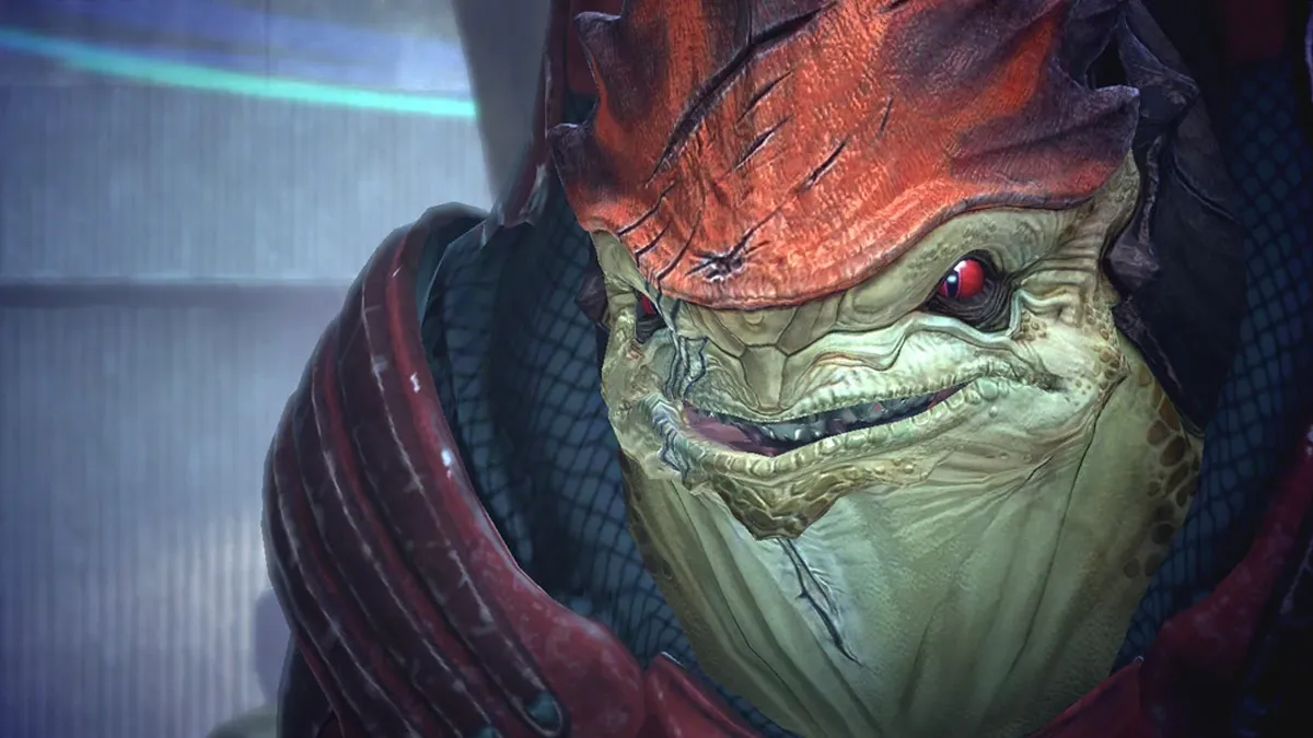 Wrex, a tank-like alien, smiles while staring at the player character in Mass Effect.