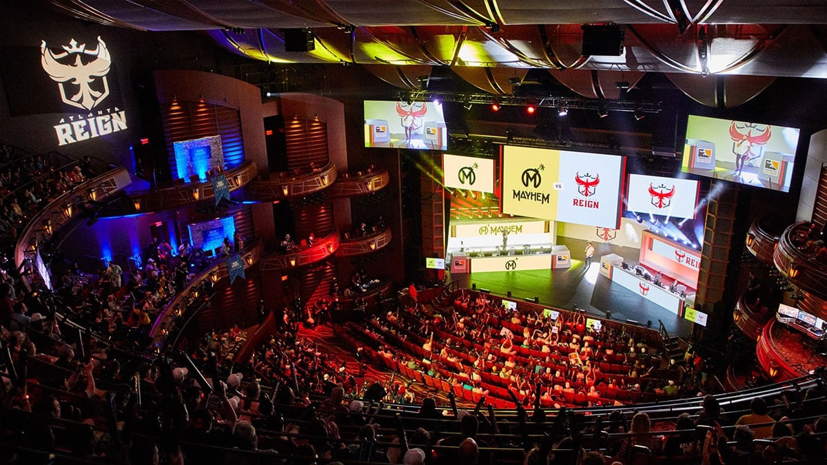 A crowd in a theater watches and cheers for live Overwatch at the Overwatch League finals.