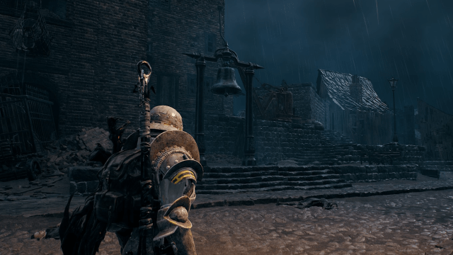A woman in heavy armor looks at an old-school bell on a large, wooden stage in Remnant 2.