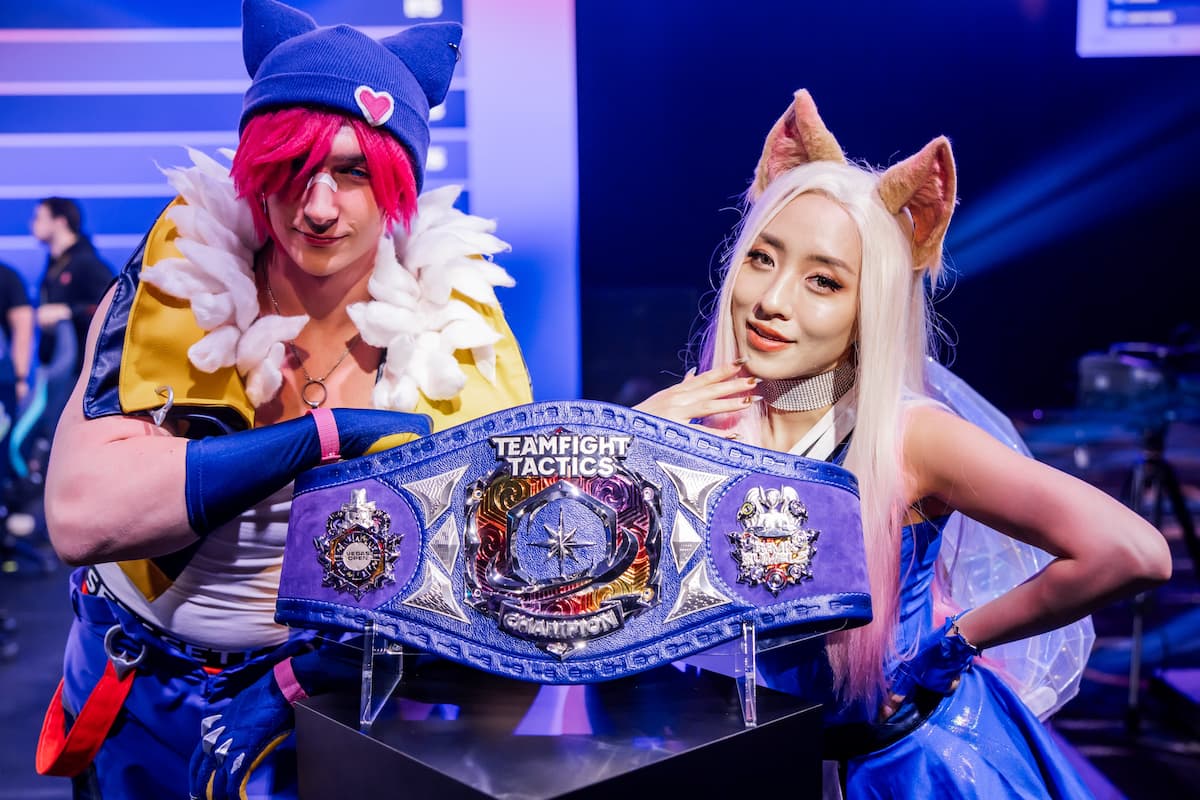Two cosplayers stand with the TFT Championship Belt at the Vegas Open.