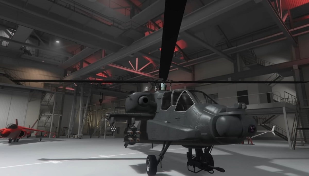 There is a shot of a garage that has multiple vehicles inside of it. There is a helicopter and fighter jet inside.