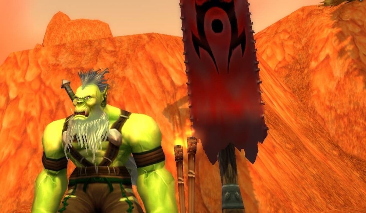 A Horde warrior standing in front of a banner by a mountainside in World of Warcraft.