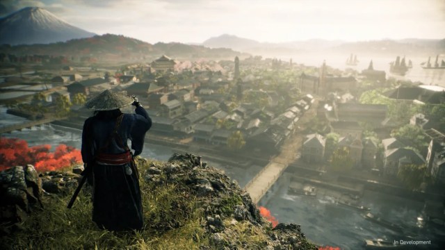 A character with a straw hat stands on a grassy overlook staring out at a town, set in old Japan.