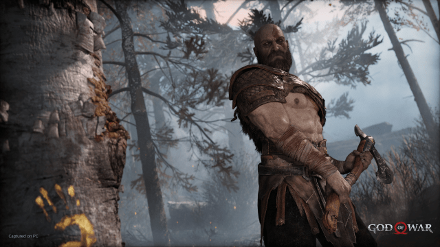 Kratos cutting down a tree in God of War.