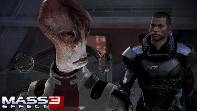 An alien with orange and white complexion, suited in scientific attire, is flanked by a man with a shaved head in full armor.
