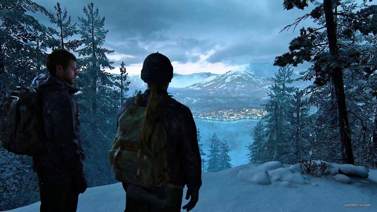 Two people looking over a town surrounded by snow in TLOU2 remastered
