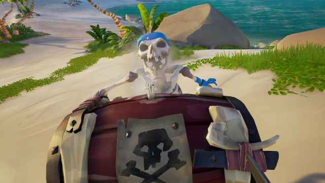 A skeleton holding a bomb with a skull on the beach in Sea of Thieves.