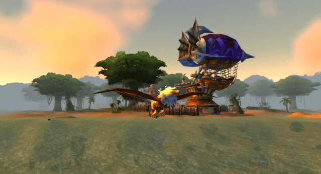 A gnome in World of Warcraft flies along the coast of Stranglethorn Vale towards Booty Bay in WoW Classic on a gryphon