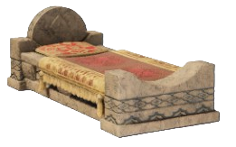 A bed with a stone headboard and foot board with red blankets on it