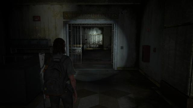 Ellie looks forwards a sign over a door, it says "Safe Deposit Lockers."