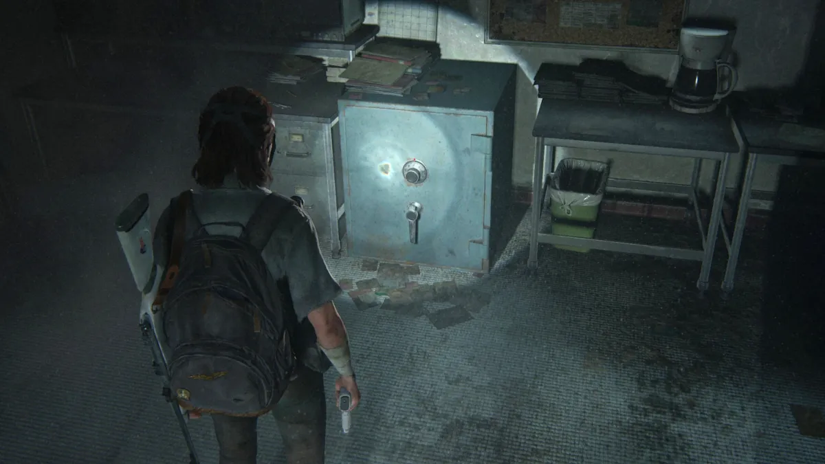 Ellie in The Last of Us Part looks at a safe