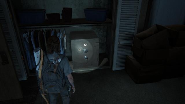 Ellie looks at a metal safe in an apartment closet
